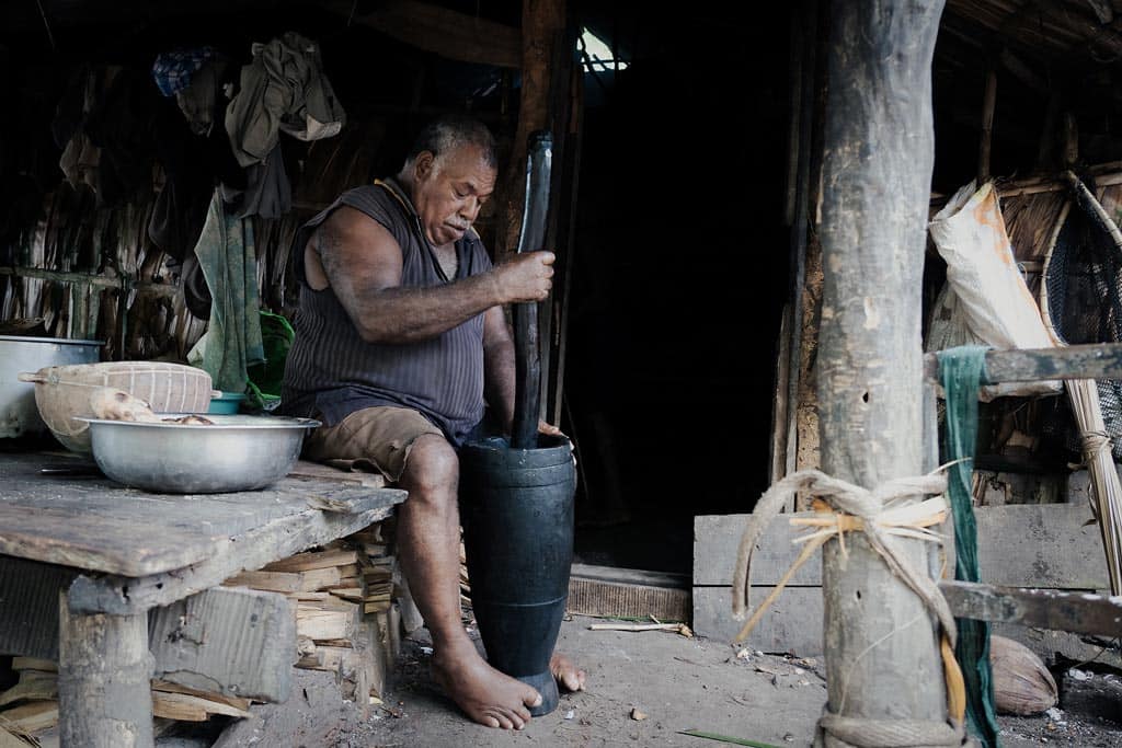 A Man Crushes Ingredients For The Evening's Pudding.
