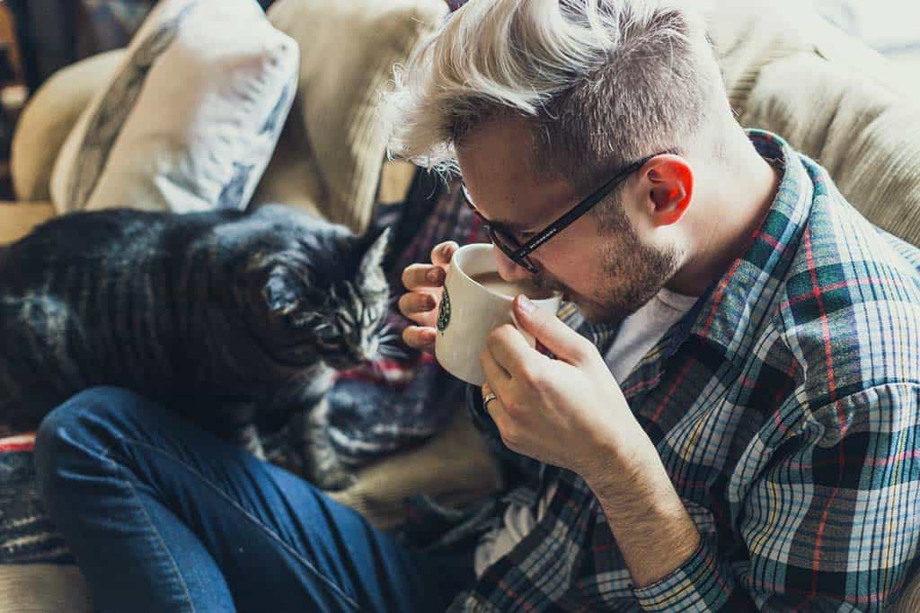 Man Sipping Coffee With A Cat