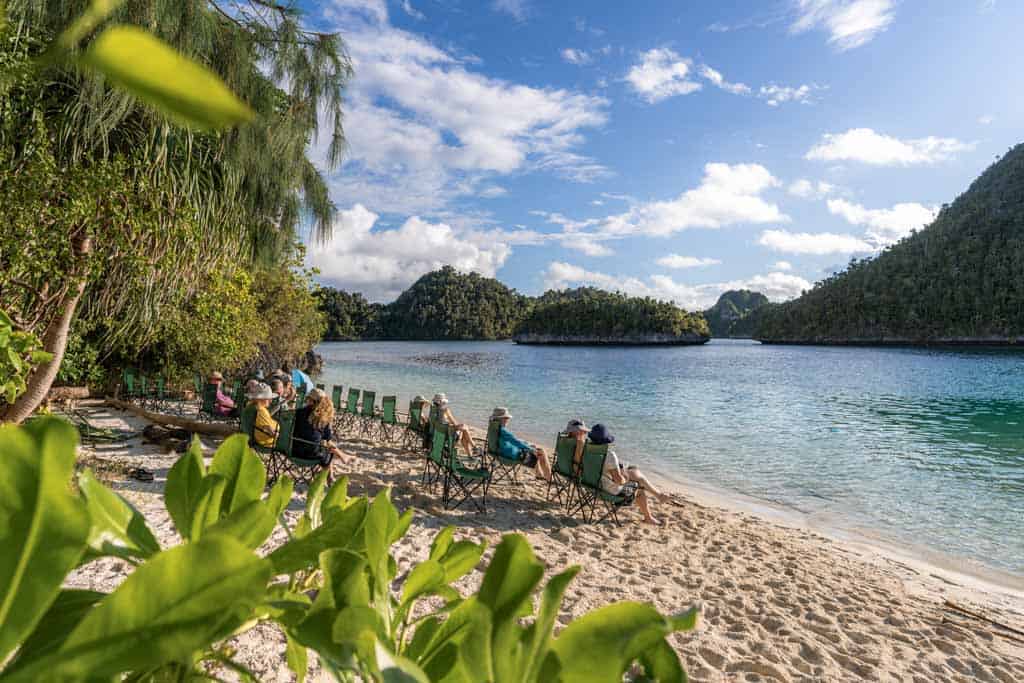 People Relaxing On The Beach In Chairs